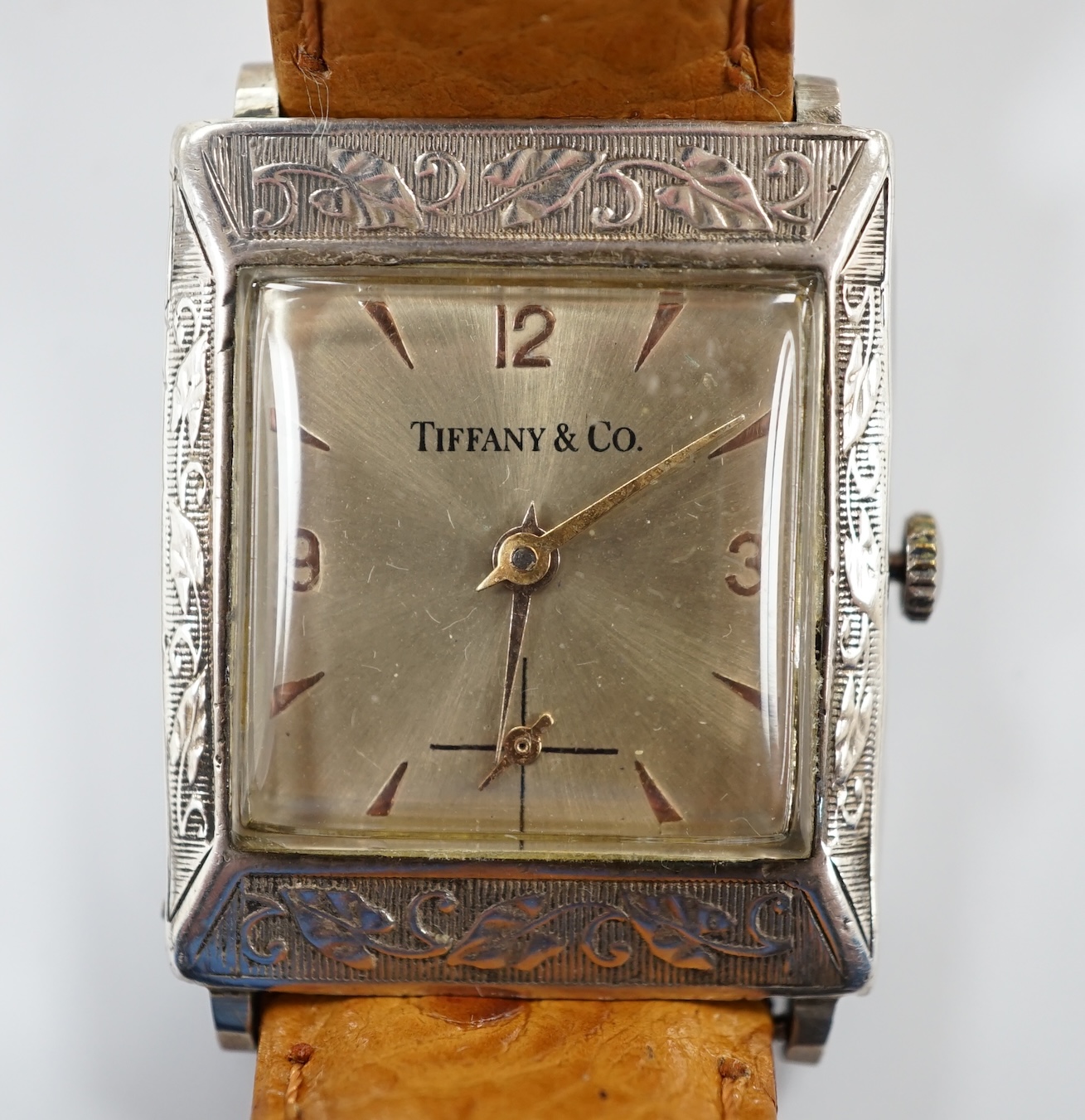 A German sterling manual wind dress wrist watch, retailed by Tiffany & Co, with baton and quarterly Arabic numerals, on an associated leather strap.